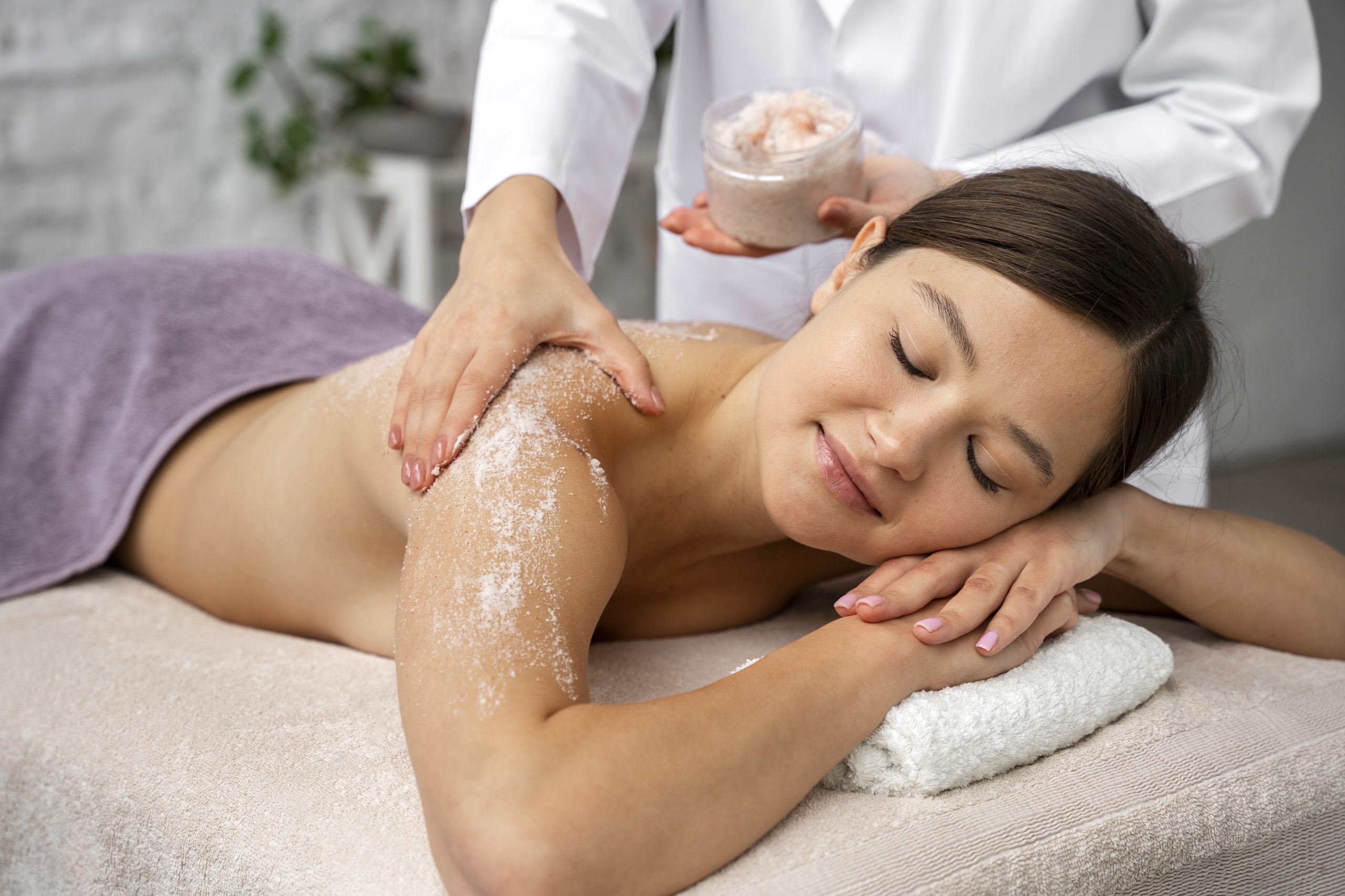 mujer recibiendo un tratamiento de exfoliación corporal